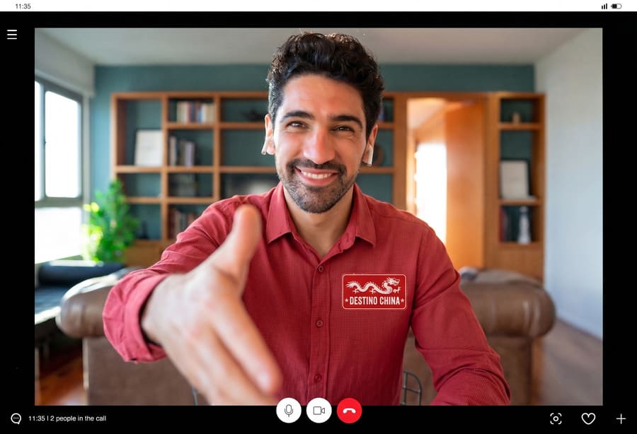 hombre con camisa roja a traves de una pantalla extendiendo la mano para estrechar