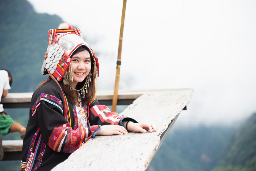 mujer vestida de traje tradicional Chino sonriendo en un mirador en Yunnan